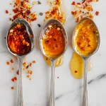 tasting spoons labeled mild, medium, and spicy, each holding different shades of hot honey